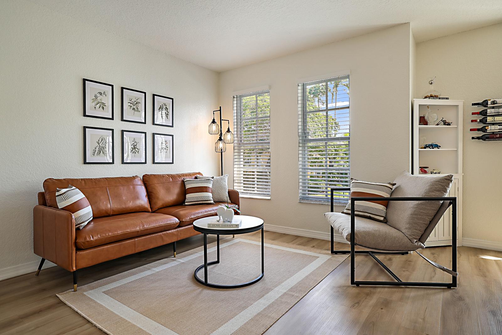 1105 Lake Shore Drive #205, Lake Park, FL 33403 - living room with leather sofa and natural light