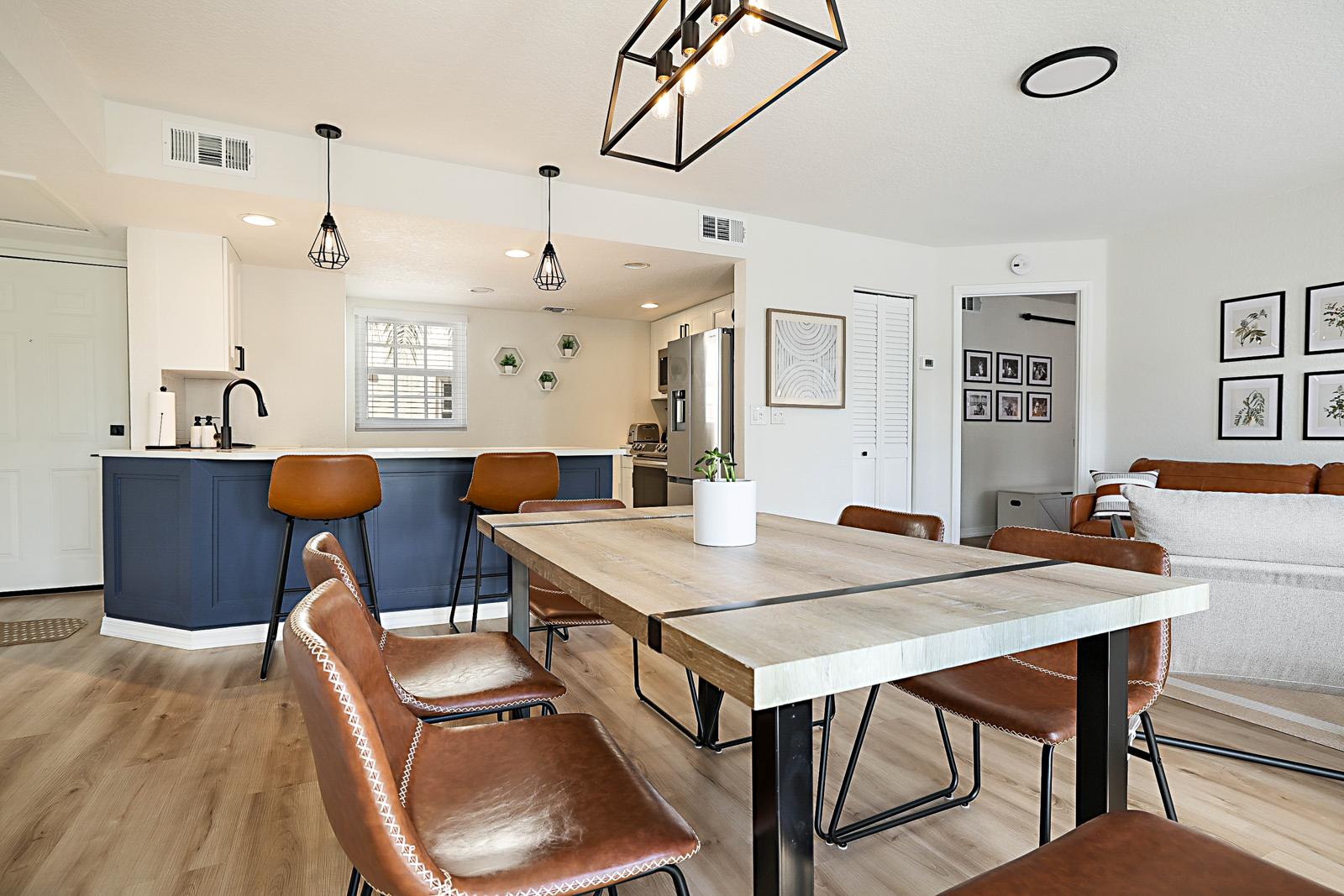1105 Lake Shore Drive #205, Lake Park, FL 33403 - island kitchen with navy cabinetry open to the dining area