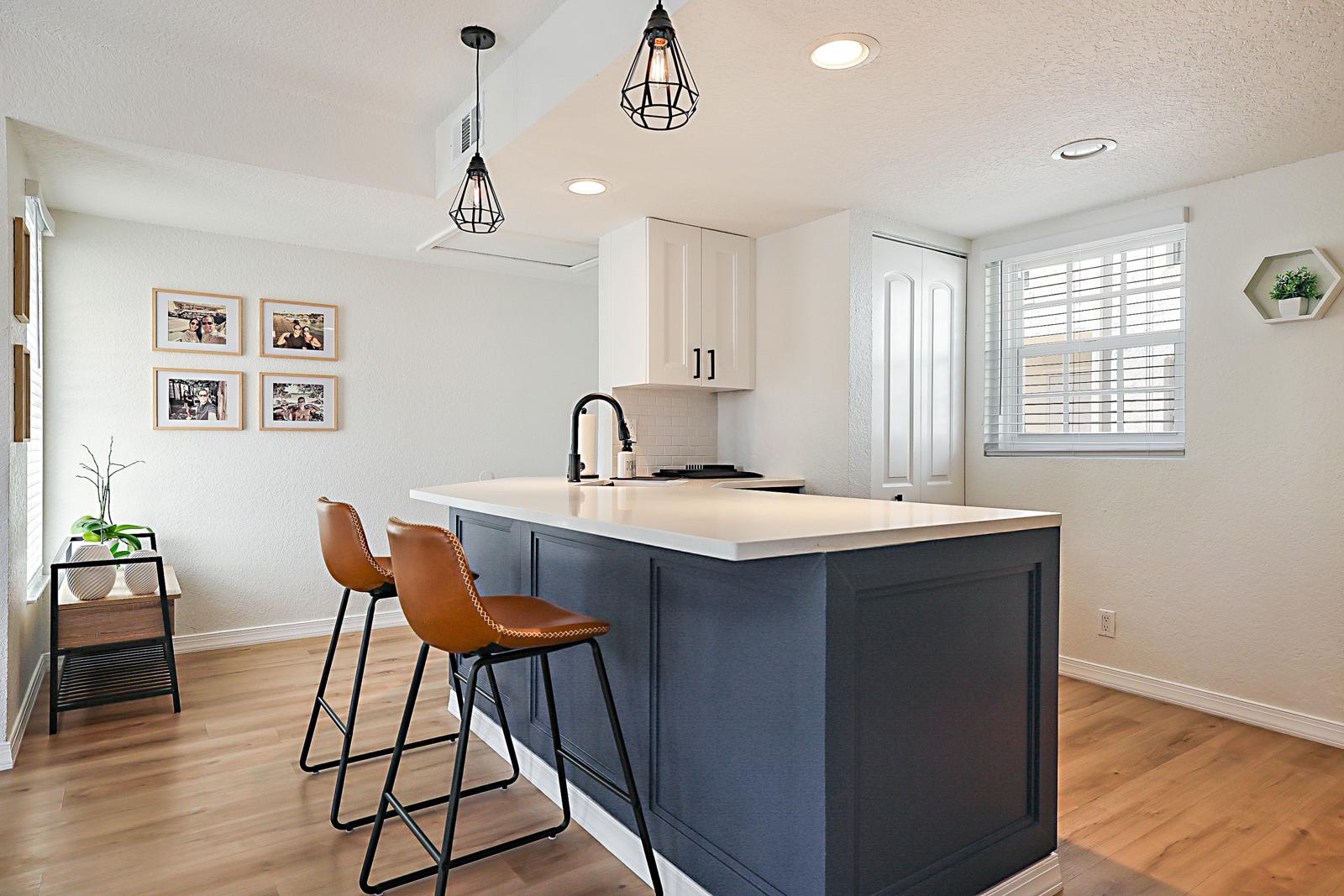 1105 Lake Shore Drive #205, Lake Park, FL 33403 - kitchen island with counter seating and pendant lights