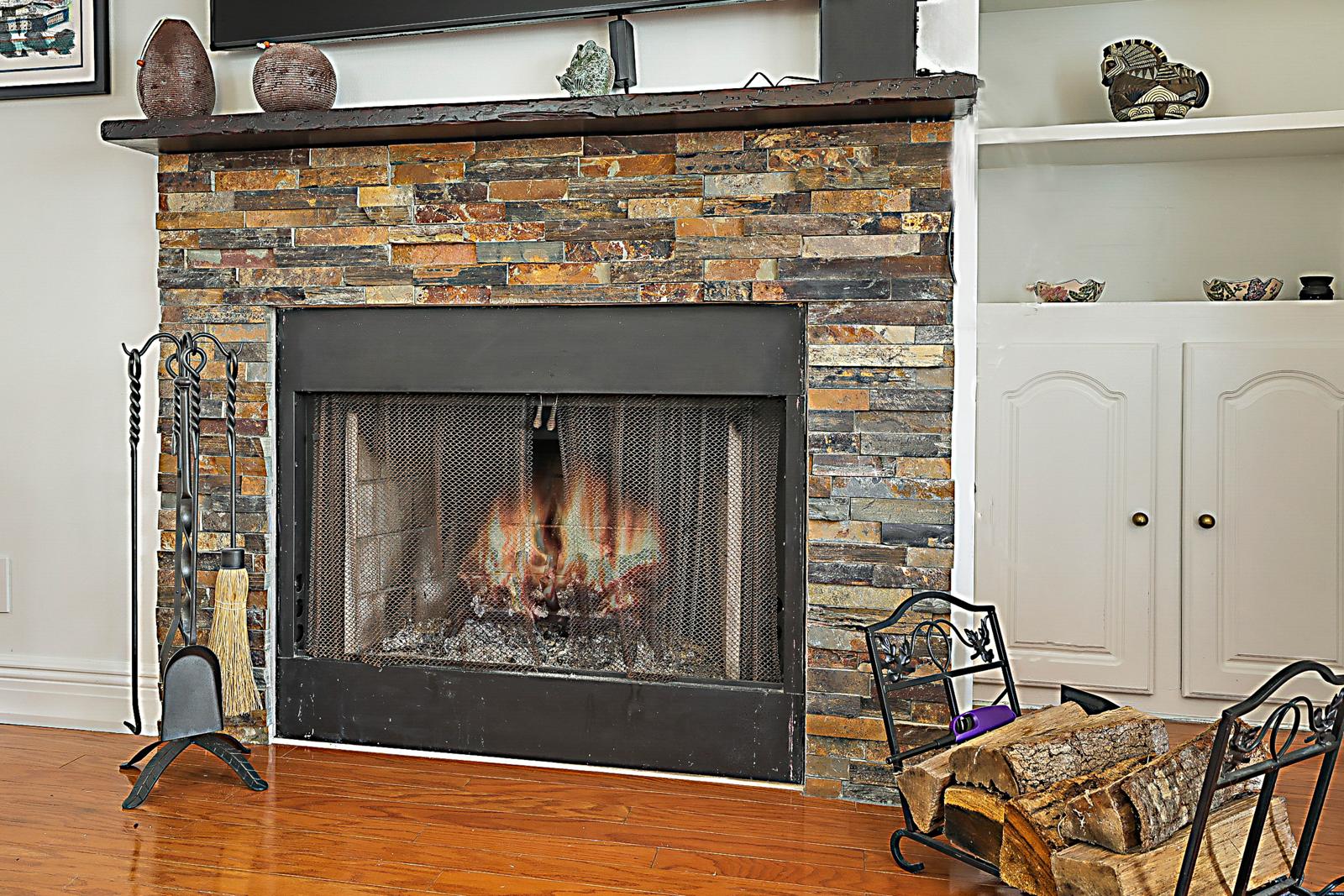 5032 Heatherhill Lane #6, Boca Raton, FL 33486 - stacked-stone wood-burning fireplace with built-in shelving