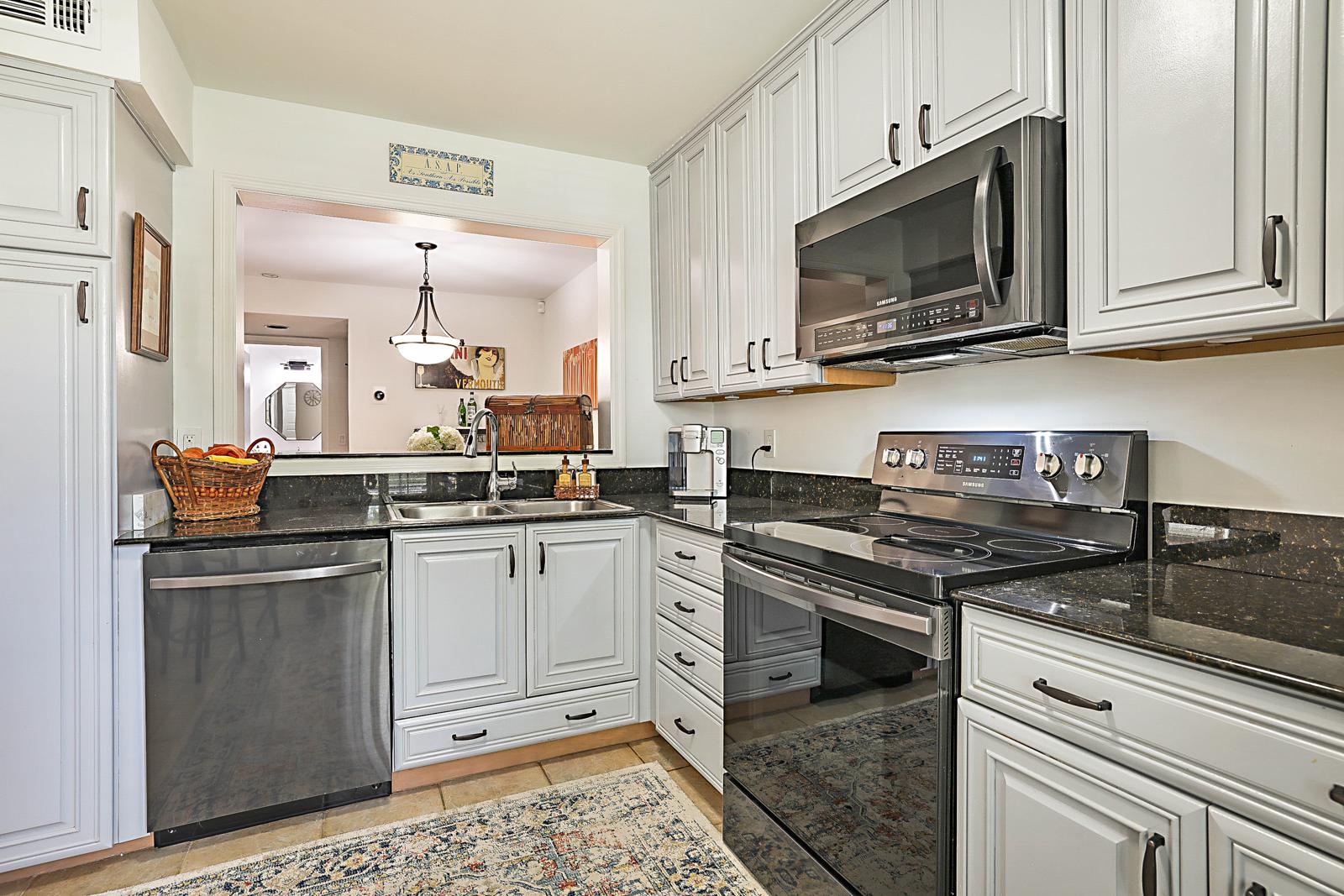 5032 Heatherhill Lane #6, Boca Raton, FL 33486 - white kitchen with granite counters and Samsung stainless appliances