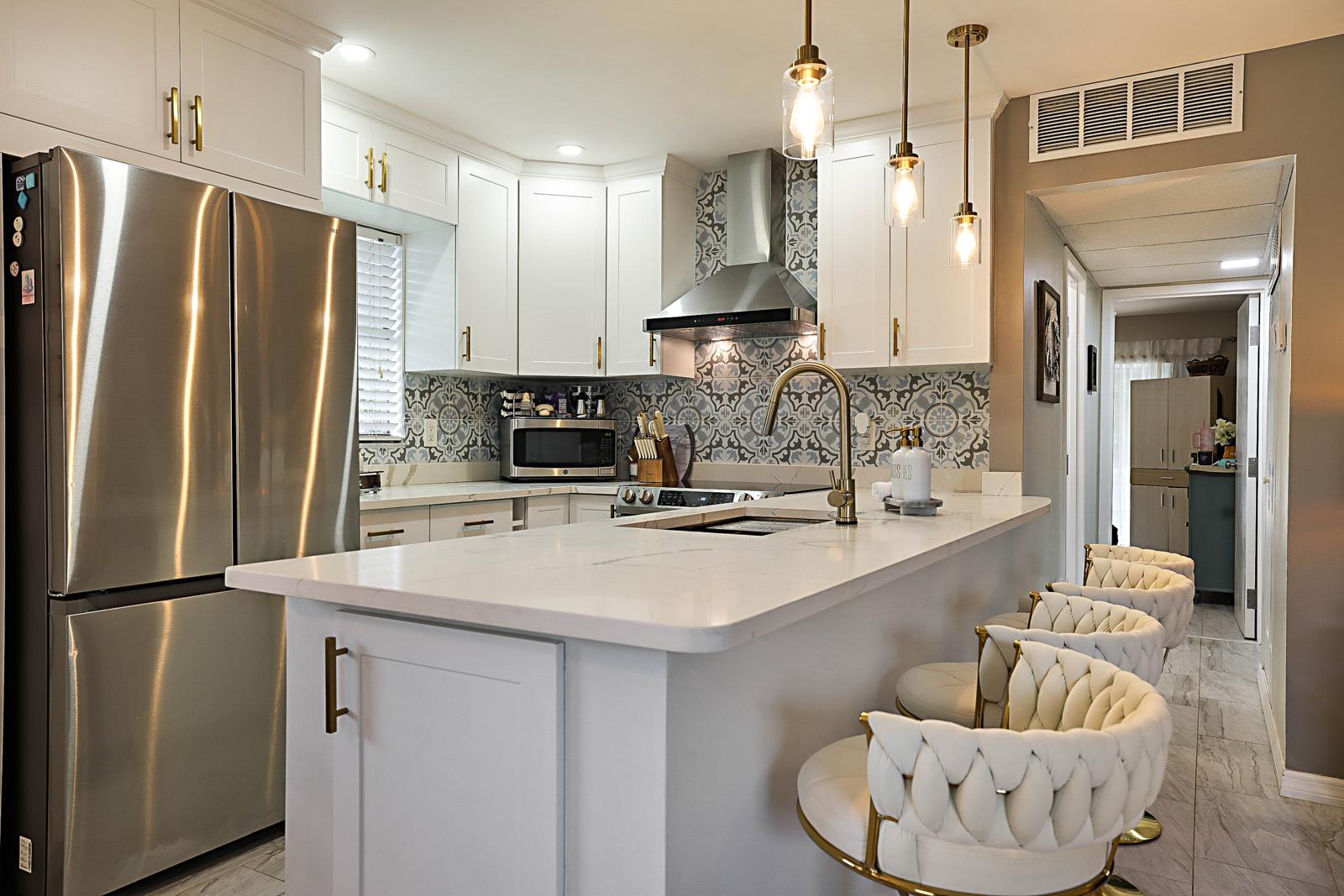 136 Tuscany B, Delray Beach, FL 33446 - kitchen island and stainless refrigerator