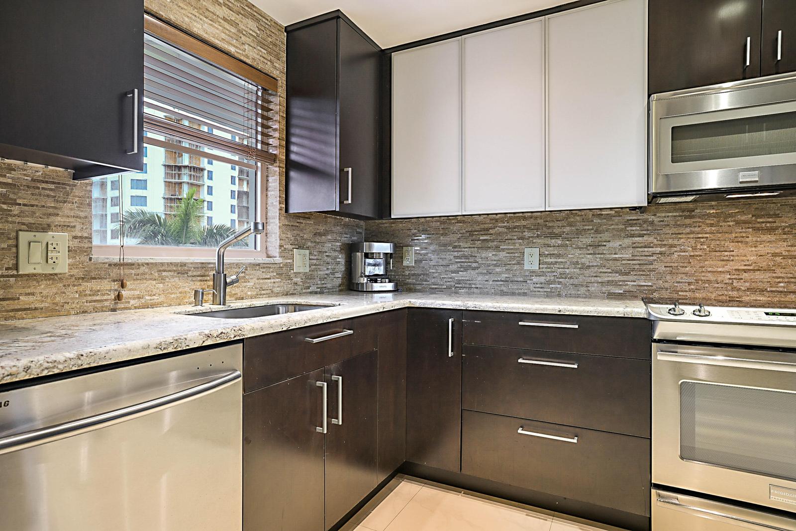 3114 S Ocean Boulevard #509, Highland Beach, FL 33487 - kitchen with espresso cabinets and stone backsplash